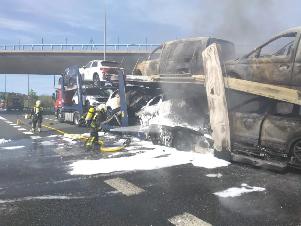 Bomberos apagando el incendio en el cami&oacute;n portacoches. / GC
