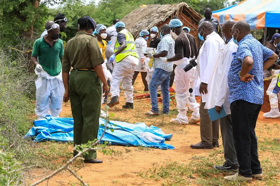 Forenses e investigadores examinan los cad&aacute;veres de las fosas donde enterraron en Kilifi (Kenya) a los presuntos miembros de una secta cristiana que ayunaron hasta morir en el sur de Kenia para reunirse con Jesucristo. EFE / STR