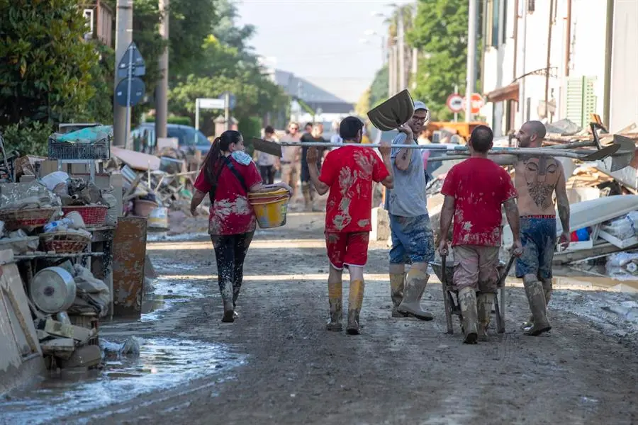 Un grupo de personas caminan por las calles afectadas por las inundaciones. EFE / FABRIZIO ZANI