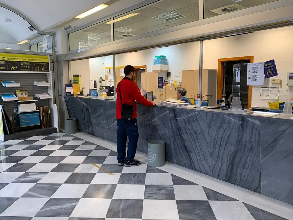 Una persona en una oficina de Correos. EP