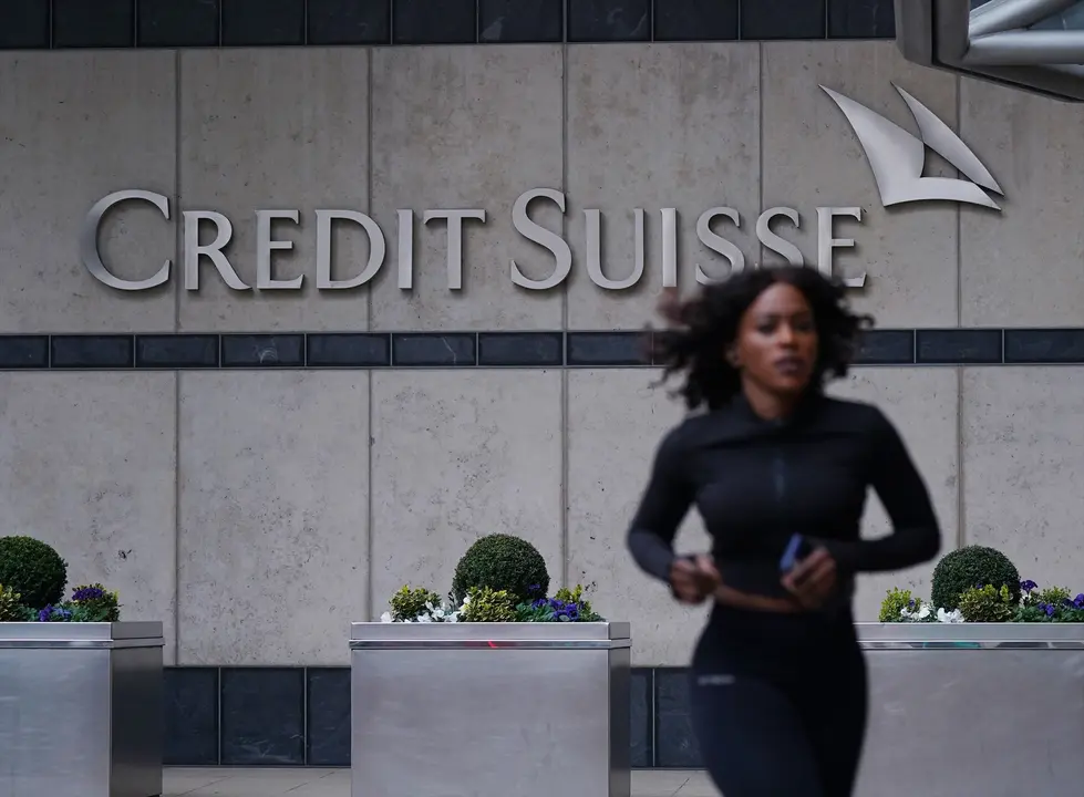 Una mujer caminando frente a las oficinas de Credit Suisse. EP / Yui Mok