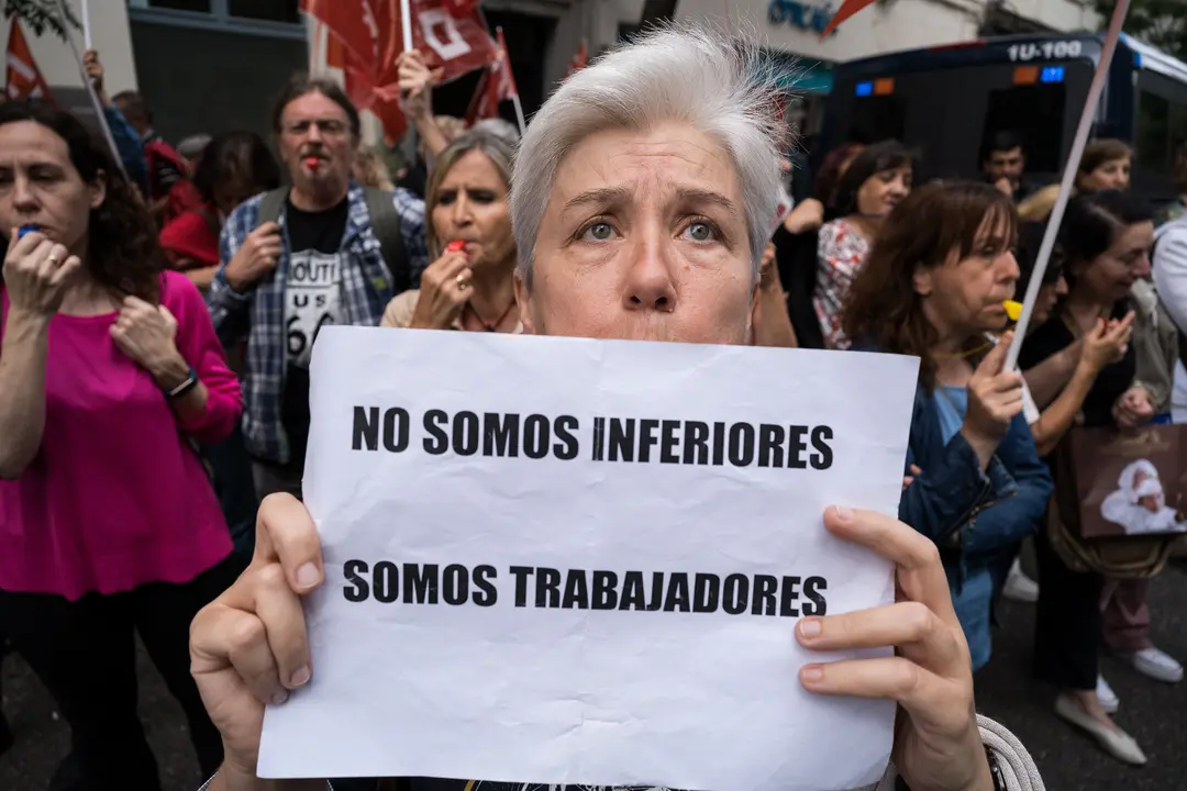 Una mujer sujeta una pancarta durante una protesta de los funcionarios de justicia frente a la sede nacional del PSOE de la calle G&eacute;nova. / Diego Radam&eacute;s