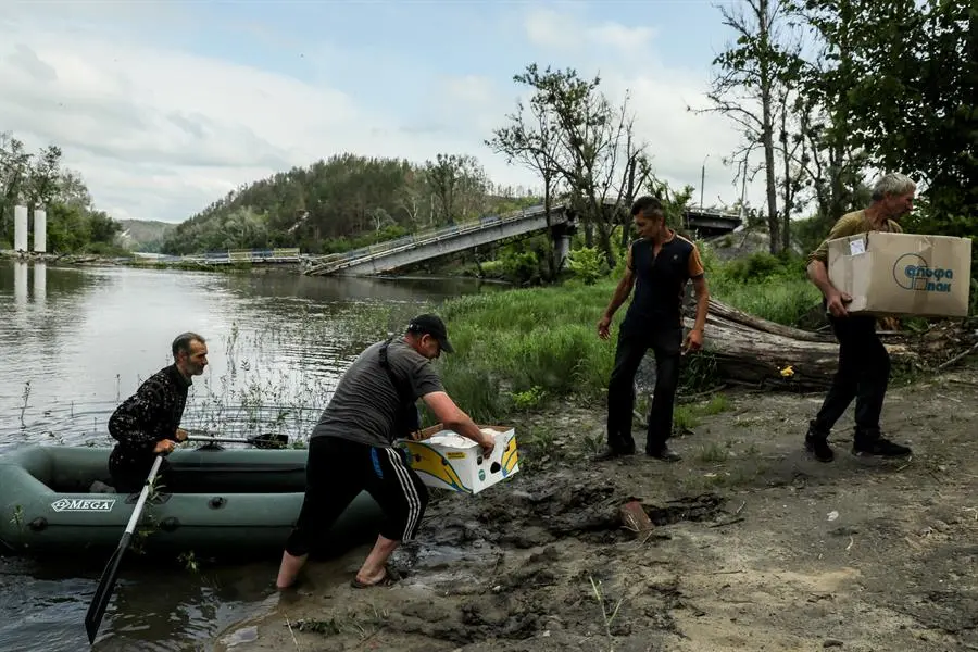 Unos hombres junto a una balsa en la zona inundada. EFE