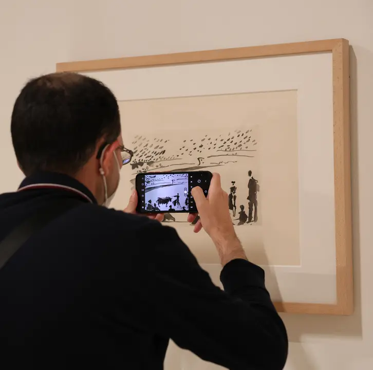 Un hombre fotograf&iacute;a con su tel&eacute;fono m&oacute;vil un dibujo de Picasso de la exposici&oacute;n. / Marta Fern&aacute;ndez