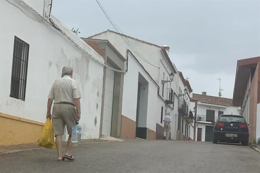 Un vecino de Cumbres Mayores (Huelva) transporta una garrafa de agua para consumir en su casa. EFE / Ferm&iacute;n Cabanillas