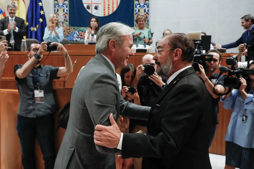 El popular Jorge Azcón (i) saluda a su antecesor en el cargo, Javier Lambán tras ser investido como presidente de Aragón durante la segunda jornada de debate este jueves, en Zaragoza. : Javier Belver