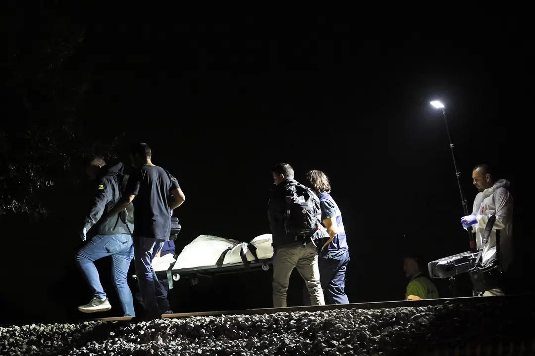 Los operarios retiran el &uacute;ltimo cad&aacute;ver despu&eacute;s de que cuatro j&oacute;venes murieran este domingo por la noche al ser arrollados por un tren a la altura de Montmel&oacute;, en la comarca del Vall&egrave;s Oriental (Barcelona), cuando un grupo de siete personas trataba de cruzar la v&iacute;a por un punto no autorizado. EFE/Alberto Est&eacute;vez
