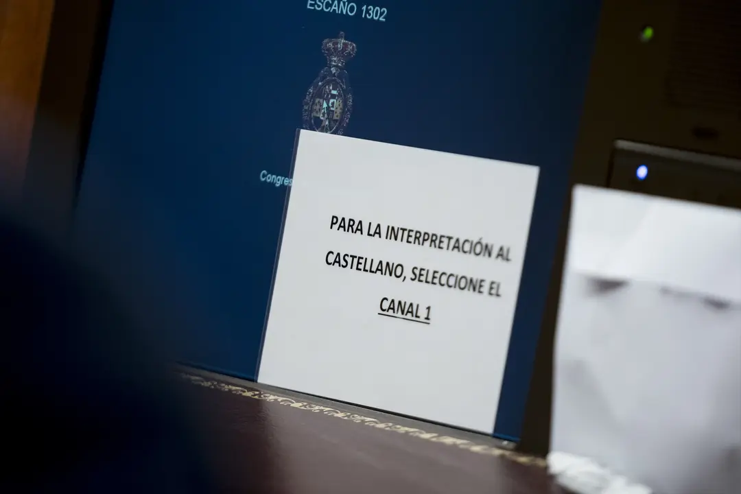 Un cartel para el uso de pinganillos en el Congreso de los Diputados, en Madrid. EP / A. P&eacute;rez Meca