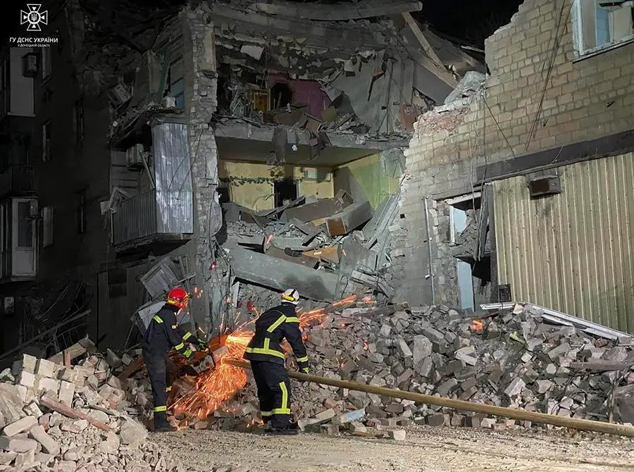 Los bomberos en uno de los edificios destruidos por un ataque. / EFE