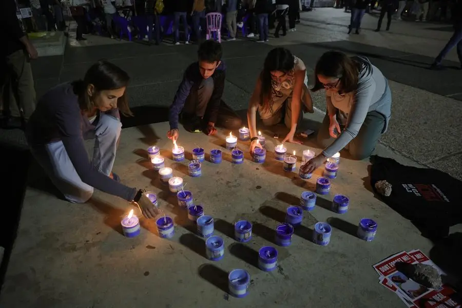 Cuatro personas encienden velas por la liberaci&oacute;n de los rehenes secuestrados por Ham&aacute;s. EFE / ABIR SULTAN