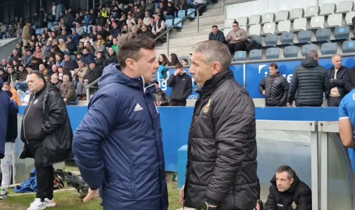 Los entrenadores se saludan tras durante el encuentro.