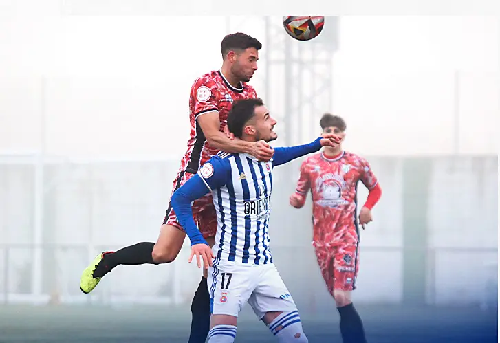 Los jugadores de la Gimn&aacute;stica y Guijuelo disputan un bal&oacute;n a&eacute;reo. / AEE