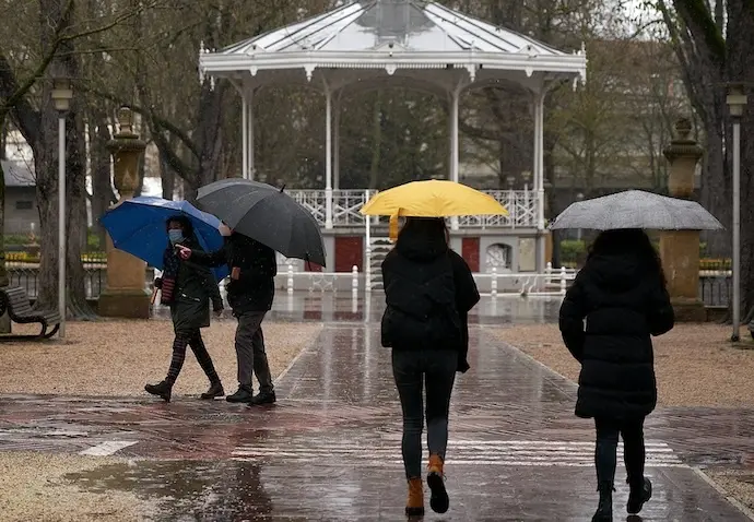 Varias personas se refugian con un paraguas de la lluvia. / Pablo Gonz&aacute;lez