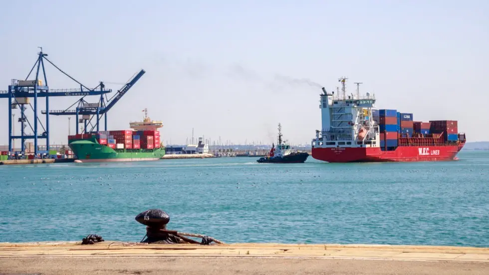 Un barco con contenedores saliendo de un puerto. EP