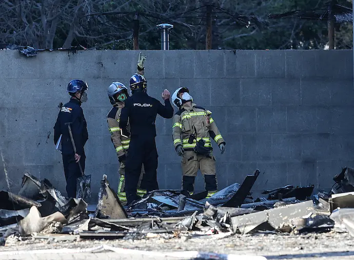 Varios agentes de la Polic&iacute;a Nacional junto al edificio incendiado del barrio de Campanar, a 24 de febrero de 2024, en Valencia, Comunidad Valenciana (Espa&ntilde;a). La Polic&iacute;a Cient&iacute;fica ha encontrado en la ma&ntilde;ana de hoy a la d&eacute;cima persona fallecida, un hombre que se encontraba desaparecido. Un incendio de grandes dimensiones arras&oacute; el pasado 22 de febrero un edificio de 14 plantas en el barrio valenciano de Campanar. El fuego, originado en el cuarto piso del inmueble, gener&oacute; una gran columna de llamas y una densa humareda que ha afectado a varias plantas del edificio. En el edificio, de 138 viviendas, resid&iacute;an unas 450 personas. El Ayuntamiento ha decretado tres d&iacute;as de luto y se han suspendido los actos falleros para este fin de semana.
24 FEBRERO 2024;DESASTRE;INCENDIO;FALLECIDOS;LLAMAS;FUEGO;LUTO;EDIFICIO
Rober Solsona / Europa Press
24/2/2024