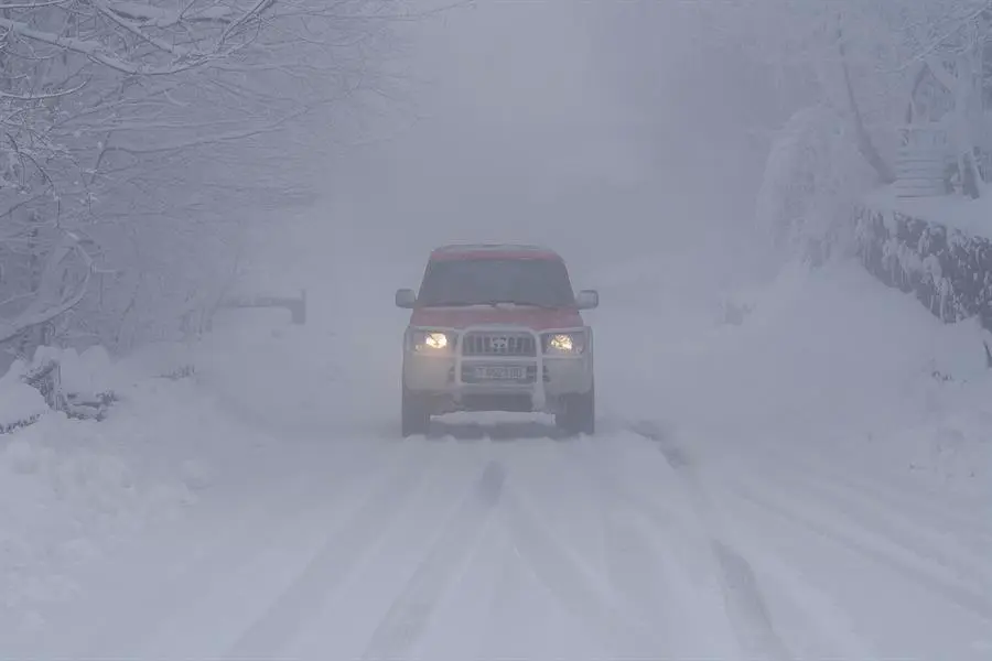 Un veh&iacute;culo circula por una carretera cubierta de nieve. / Archivo/ EFE/ Eiseo Trigo