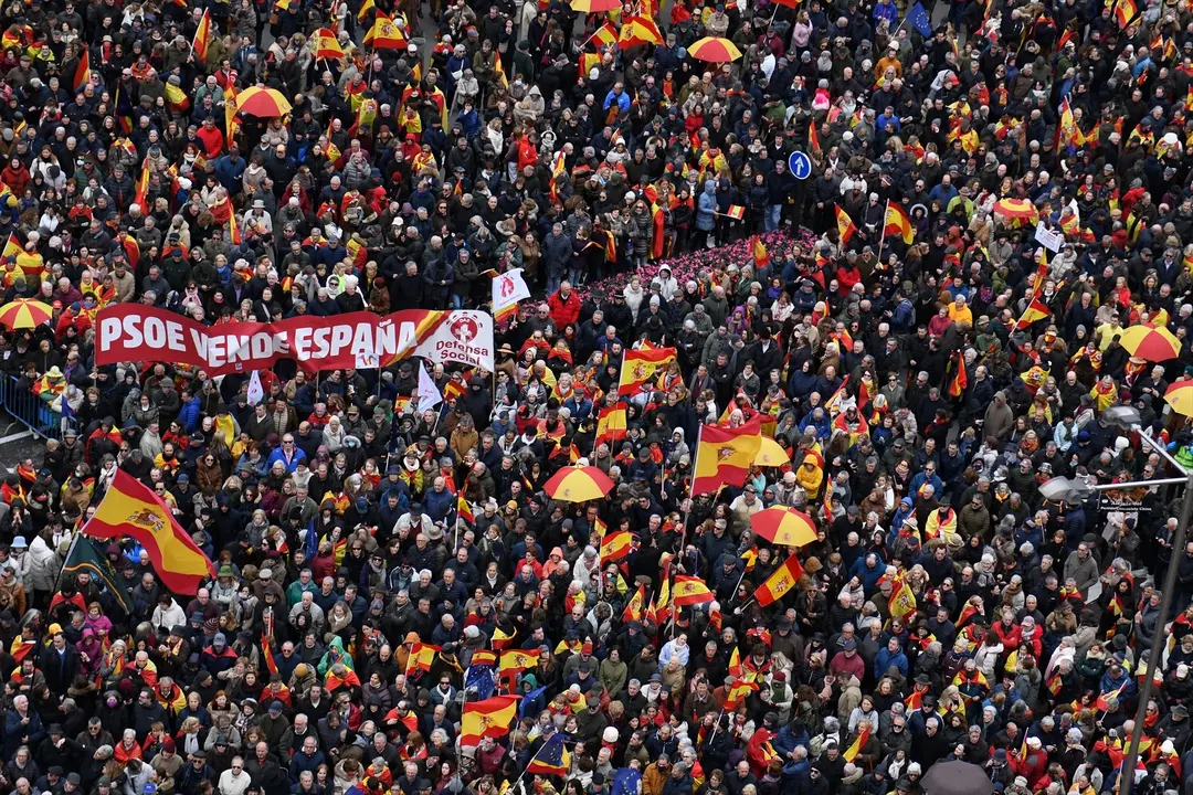 Decenas de personas durante una concentraci&oacute;n donde piden la dimisi&oacute;n de Pedro S&aacute;nchez, y un cartel con la frase "PSOE vende Espa&ntilde;a". EP / Fernando S&aacute;nchez