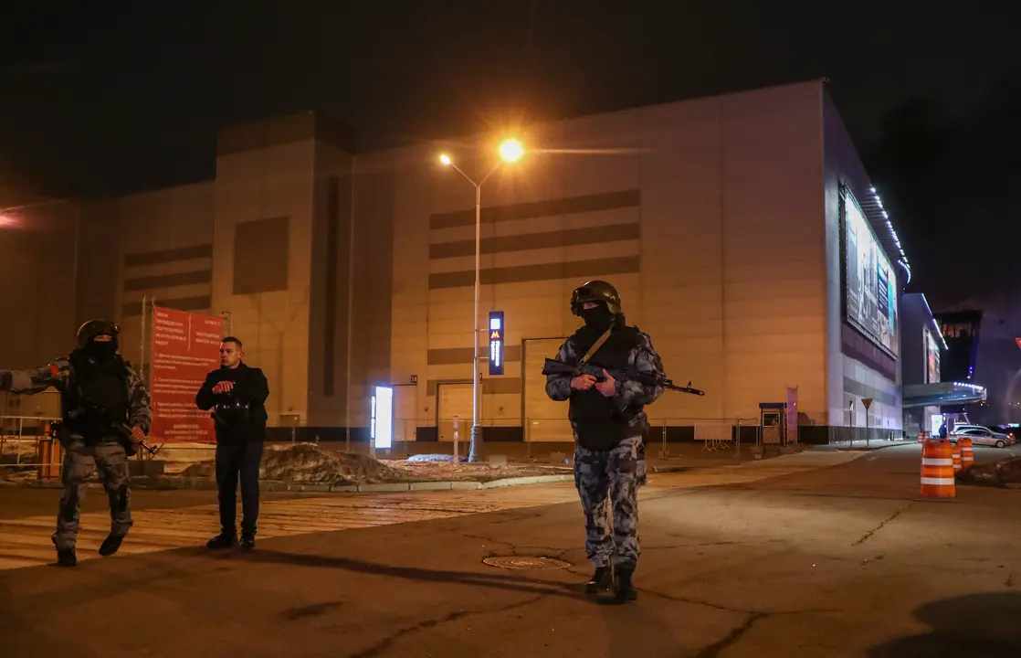 Polic&iacute;as rusos hacen guardia cerca de la sala de conciertos Crocus City Hall en llamas tras un tiroteo en Krasnogorsk, en las afueras de Mosc&uacute;. / MAXIM SHIPENKOV