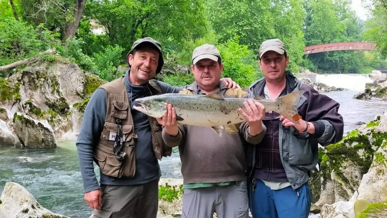 Fotograf&iacute;a de tres pescadores con un salm&oacute;n en el coto de pesca Puente Viesgo.