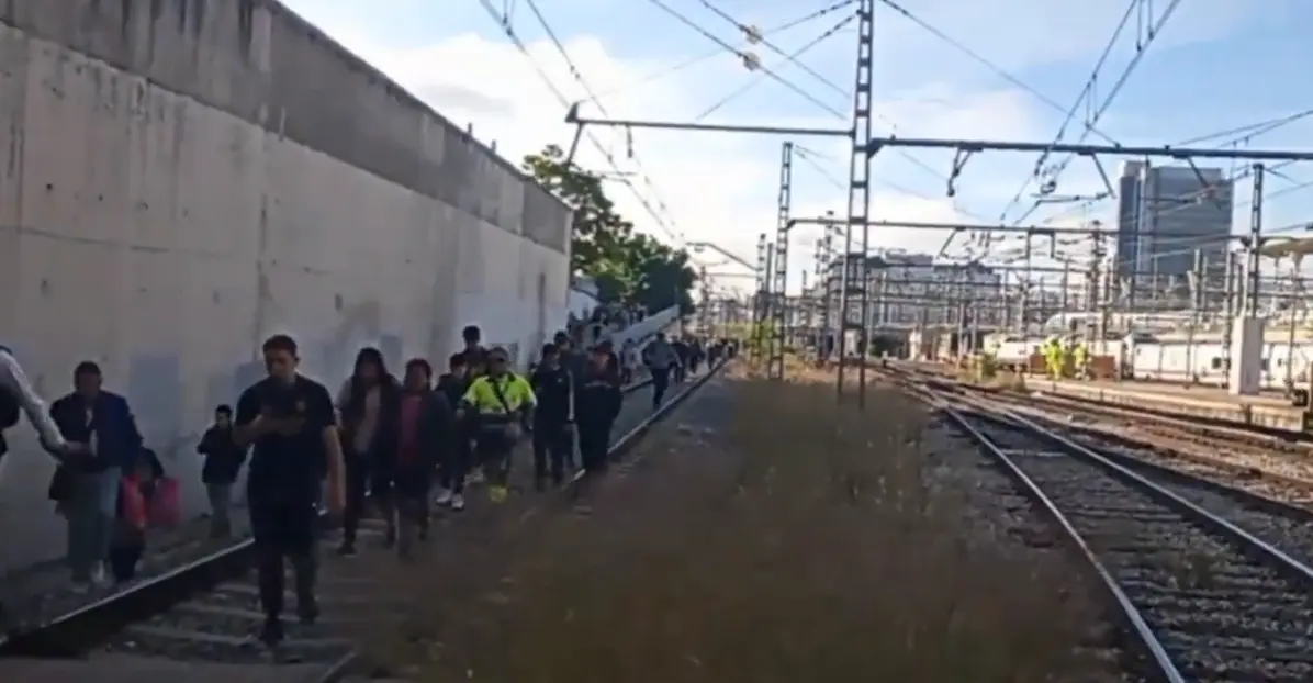 Los pasajeros caminando por las v&iacute;as del tren tras el incidente con el tren de cercan&iacute;as. / Captura de un v&iacute;deo