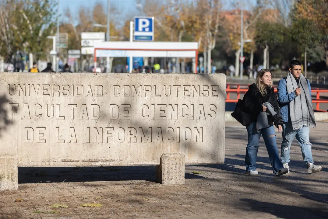 Dos personas caminan junto a la Facultad de Ciencias de la Informaci&oacute;n, en la Universidad Complutense de Madrid. Eduardo Parra / Archivo