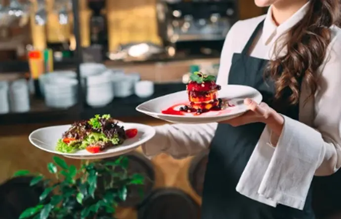 una camarera lleva los platos en un restaurante. / A.S.