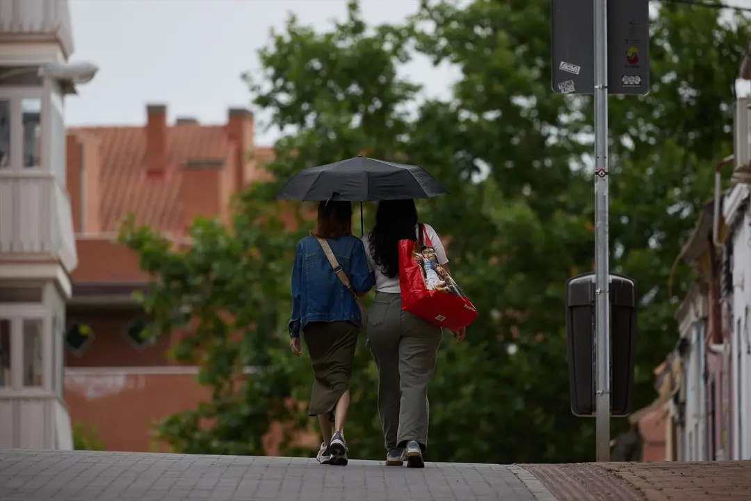 Dos mujeres se protegen de la lluvia con un paraguas. Jes&uacute;s Hell&iacute;n / Archivo