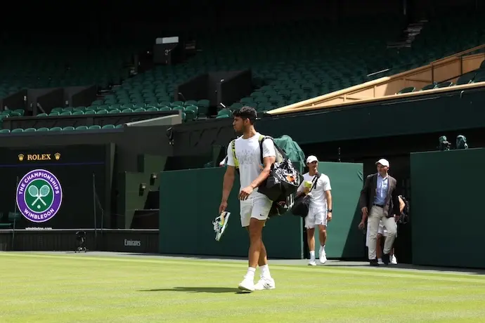 El tenista espa&ntilde;ol Carlos Alcaraz se muestra optimista durante un entrenamiento en Wimbledon, prepar&aacute;ndose para defender su t&iacute;tulo y a&ntilde;adirlo a su reciente victoria en Roland Garros, a pesar de una breve preparaci&oacute;n sobre hierba tras su eliminaci&oacute;n en Queen's.