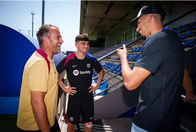 El entrenador del FC Barcelona, Hansi Flick, charla con sus jugadores Pedri y Ronald Araujo en la Ciutat Esportiva Joan Gamper. /Germ&aacute;n Parga