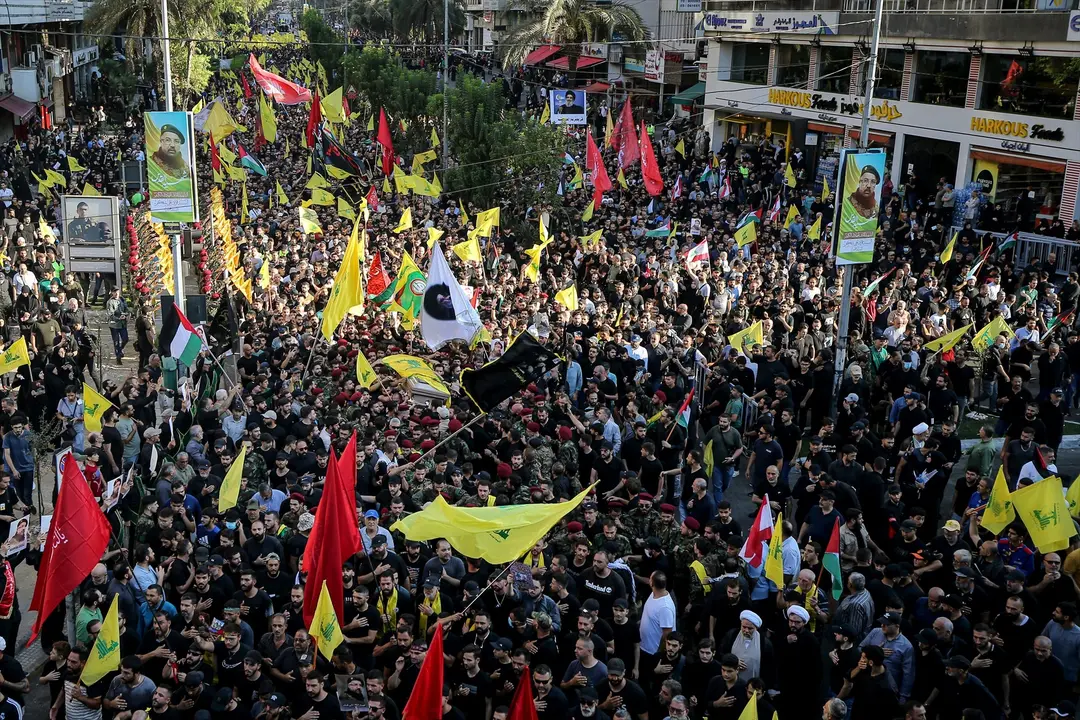 La gente ondea banderas durante el funeral del m&aacute;ximo comandante de Hezbol&aacute;, Fuad Shukr, en los suburbios del sur de Beirut. Marwan Naamani
