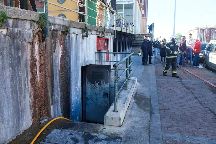 Bomberos y vecinos en las inmediaciones del incendio. / EP