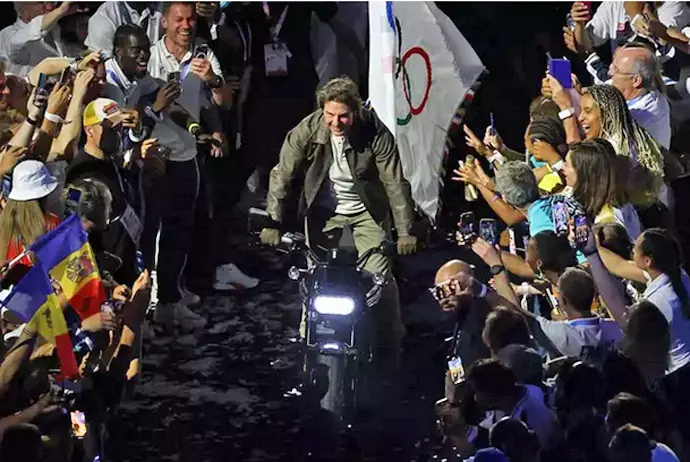 El actor estadounidense Tom Cruise, coge la bandera ol&iacute;mpica subido en una moto. / EP