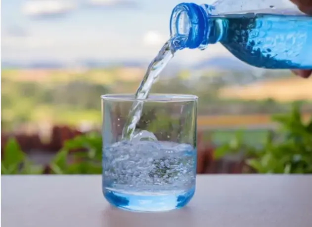 Una persona echando agua a un vaso. / A.S.