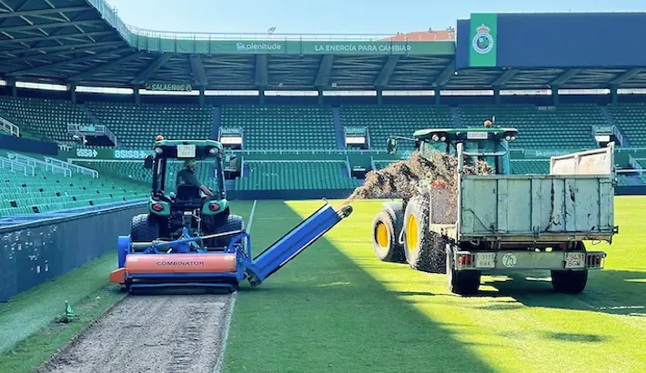 Varias maquinas en el cesped de la casa del Racing de Santander donde se puede apreciar el cesped levantado. / x