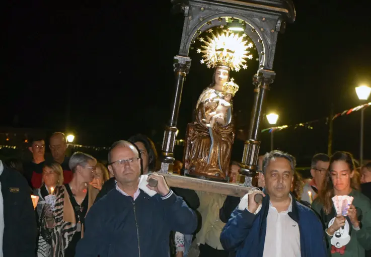 A la derecha, portando la estatuilla de la Virgen, el alcalde de Pi&eacute;lagos durante la procesi&oacute;n. / ALERTA