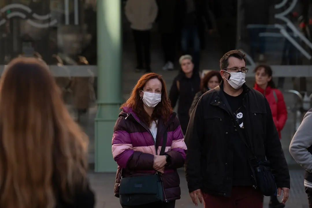 Varias personas con mascarillas a las afueras de un hospital. / David Zorrakino