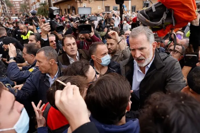 PAIPORTA (VALENCIA), 03/11/2024.- El rey Felipe habla con vecinos afectados por la riada, durante su visita a Paiporta este domingo. Gritos de 'fuera', as&iacute; como lanzamiento de barro, est&aacute;n recibiendo a la comitiva de los reyes de Espa&ntilde;a, el presidente del Gobierno, Pedro S&aacute;nchez, y el president de la Generalitat, Carlos Maz&oacute;n, a su llegada al centro de Paiporta. Numerosas personas indignadas han recibido con insultos a la comitiva y se han encarado con ella, mientras que tanto el rey como la reina ha intentado mediar con j&oacute;venes que se les han acercado. EFE/ Ana Escobar