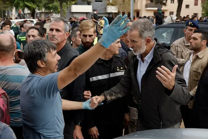 PAIPORTA (VALENCIA), 03/11/2024.- El rey Felipe (d) habla con un damnificado por la riada, durante su visita a Paiporta este domingo. Gritos de 'fuera', as&iacute; como lanzamiento de barro, est&aacute;n recibiendo a la comitiva de los reyes de Espa&ntilde;a, el presidente del Gobierno, Pedro S&aacute;nchez, y el president de la Generalitat, Carlos Maz&oacute;n, a su llegada al centro de Paiporta. Numerosas personas indignadas han recibido con insultos a la comitiva y se han encarado con ella, mientras que tanto el rey como la reina ha intentado mediar con j&oacute;venes que se les han acercado. EFE/ Biel Ali&ntilde;o