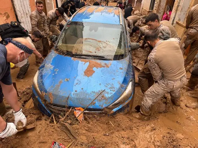 Varios militares ayudando a sacar un coche del lodo. / Red x