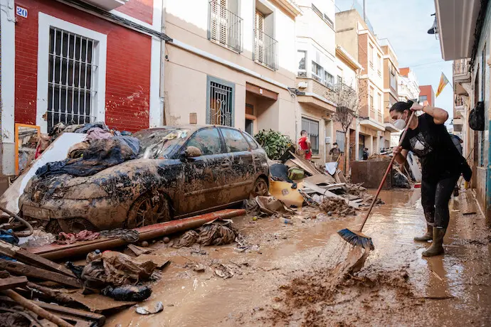 Una persona trata de limpiar el lodo en Catarrja. / EP