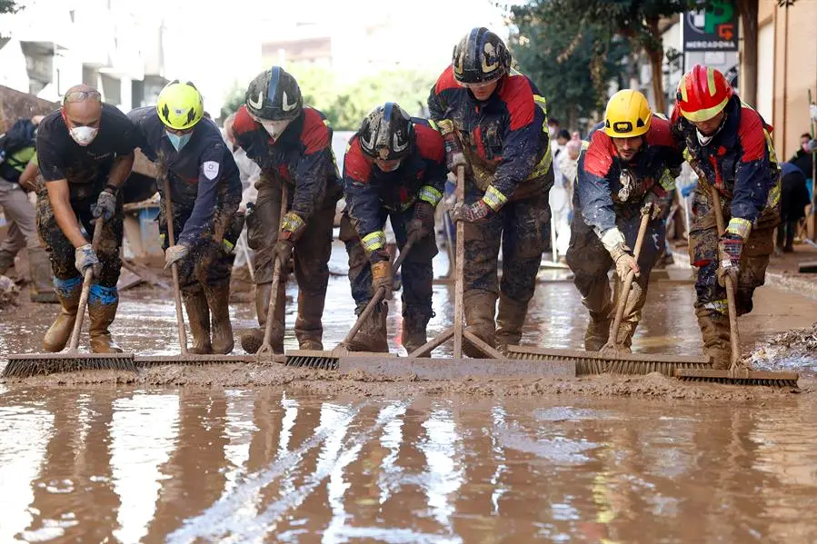 CATARROJA (VALENCIA), 10/11/2024.-Decenas de voluntarios continuan extrayendo lodo de las calles, este domingo, en la poblaci&oacute;n de l`horta Sud de Catarroja. Doce d&iacute;as despu&eacute;s de la dana, los servicios de emergencia siguen buscando a personas desaparecidas en Valencia e intentan dotar a la zona de servicios b&aacute;sicos, mientras miles de voluntarios colaboran sin descanso en los pueblos arrasados por el agua y se encara una semana que traer&aacute; la paulatina reapertura de comunicaciones con el &aacute;rea metropolitana y el centro de Espa&ntilde;a.- EFE/Miguel &Aacute;ngel Polo