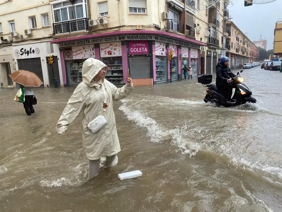 Una mujer hace fotos con el agua hasta las rodillas en M&aacute;laga donde las fuertes trombas de agua y granizo que se registran este mi&eacute;rcoles han causado inundaciones y la acumulaci&oacute;n de grandes balsas en algunas de las principales avenidas de todos los distritos de la ciudad.EFE/Mar&iacute;a Alonso