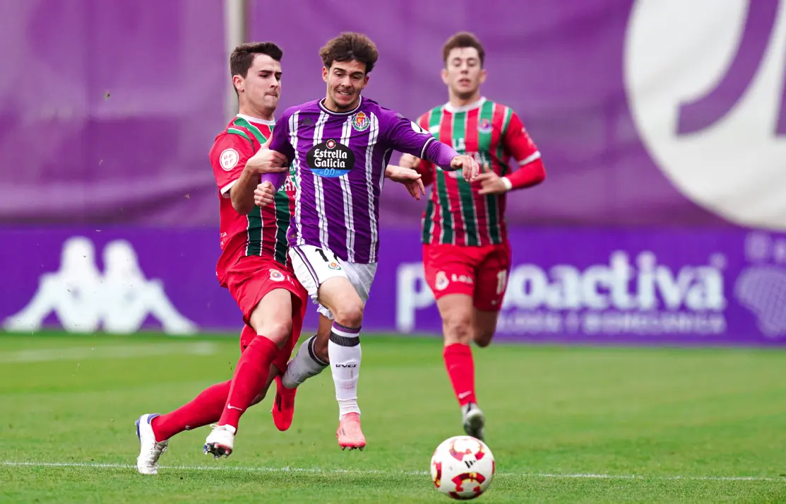 Duelo de intensidad: dos jugadores se disputan el bal&oacute;n en una acci&oacute;n clave del encuentro entre la Gimn&aacute;stica de Torrelavega y el Valladolid Promesas.