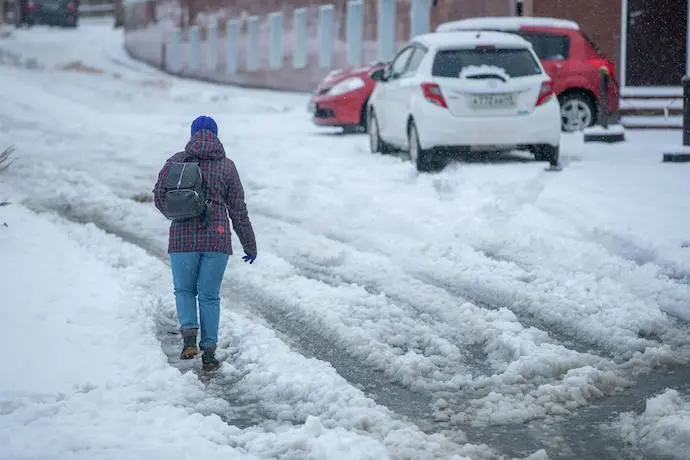 Una persona camina por una calle con niebe. / A.E