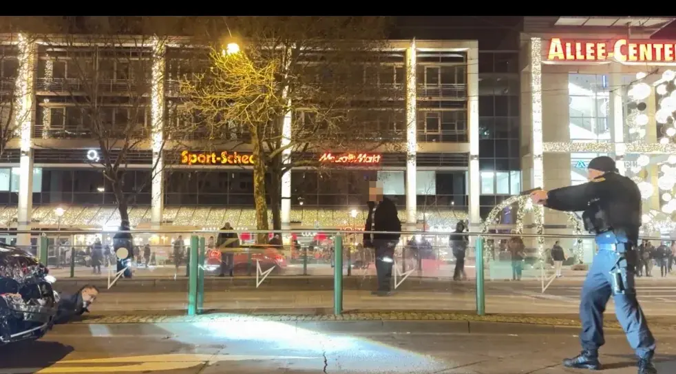 Esta foto muestra al perpetrador (50, izquierda) tirado en el suelo. A pocos metros hay un polic&iacute;a con el arma en la mano. El fald&oacute;n delantero del coche est&aacute; muy da&ntilde;ado.