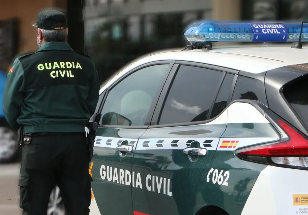Un agente de la Guardia Civil, de espaldas, de pie junto a un veh&iacute;culo oficial. / EP