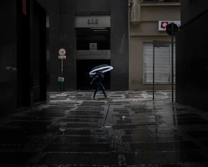 Una persona va co un paraguas por la calle. / A.E