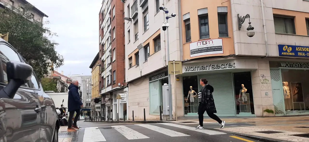 Peatones cruzan la confluencia de las calles Consolaci&oacute;n y Joaqu&iacute;n Hoyos, bajo la vigilancia de las c&aacute;maras pol&eacute;micas instaladas por el Ayuntamiento de Torrelavega. / S.D.