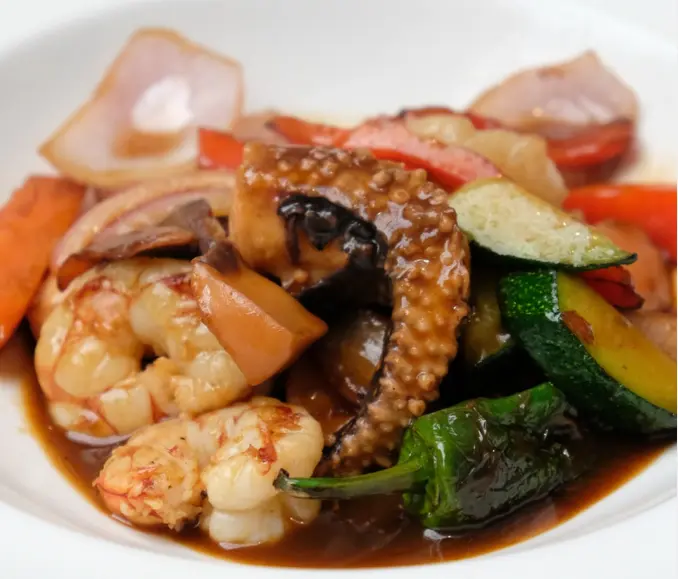 Wok de cach&oacute;n y gambas con unagi y verduras, uno de los platos del restaurante. / IG