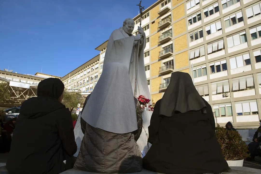 Varias personas rezan frente al hospital donde se encuentra ingresado el papa Francisco. / ALESSIA GIULIANI